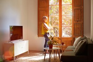 Shot of a mature woman standing by a window at home deep in thought