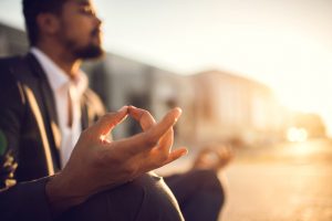 Person in business suit meditates, calmly smiling