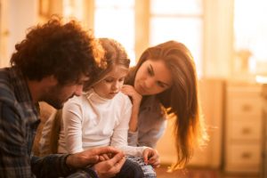 Two parents comfort and console distressed child