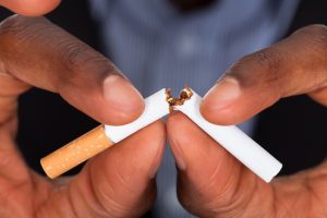 Hands breaking a cigarette in two