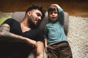 Father and son laying on carpet