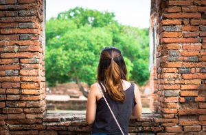 Person looking out brick window