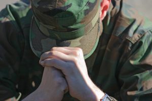 Soldier looking down with head in hands