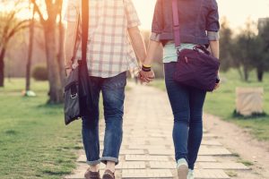 Young couple holding hands and walking outside