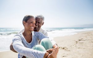 Happy mature couple sits on beach