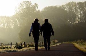 Rear view of two adults taking a walk and talking on a cold morning