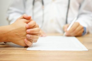 Doctor filling out paperwork with patient