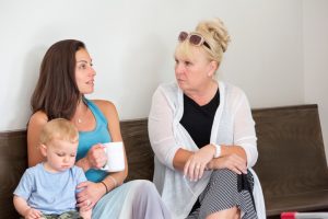 Mother with toddler son talks to her mother in law