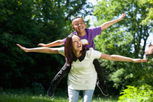 mother and child pretending to fly outside