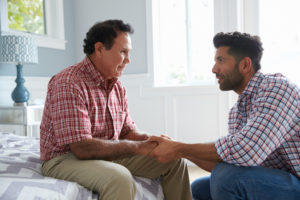 Son sitting with aging father with dementia