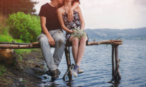 Teen couple sitting by the lake