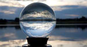 Crystal ball on stand by sea reflects cloud and sea view