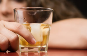 Person holding whiskey glass
