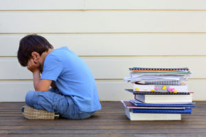 Boy with back to pile of school work