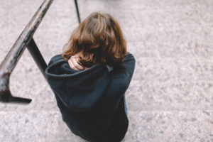 Rear view of teen sitting on stairs