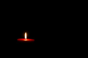 Red candle against black background