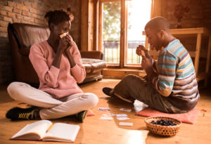 Young couple sits in living room and plays cards together