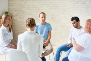 People sitting in group setting having a serious discussion