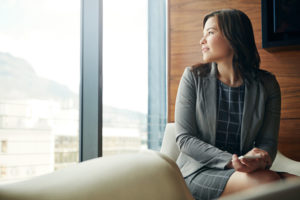 Shot of a young businesswoman sitting in an office chair holding phone