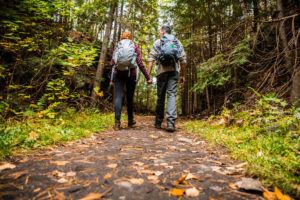 Couple hiking in mountains holds hands and walks together