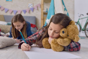 Sisters on the floor together, coloring