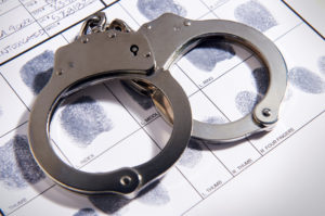 Handcuffs placed atop fingerprint chart in file