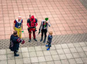 Five people in costumes form a semi-circle outdoors.