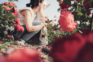 Mother and daughter gardening outdoors, taking care of flowers