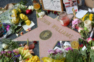 Robin Williams' star on the Hollywood Walk of Fame is surrounded by flowers and various memorial tributes.