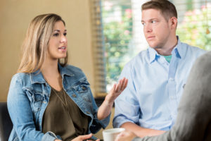 Couple (male and female) talk seriously in counselor's office