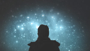 Close up rear view photo of person with ponytail looking at constellations in starry cloud