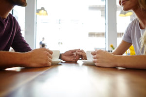 Couple holding hands at table on coffee date