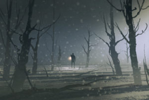 Distant person holds up light in middle of dim, desolate forest with fog