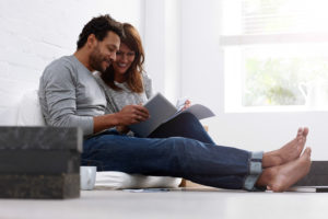 Couple on floor sitting together looking through papers