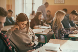 Group of students at desks in class ignoring each other