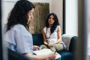 Counselor takes notes and listen to person who has mildly frustrated expression