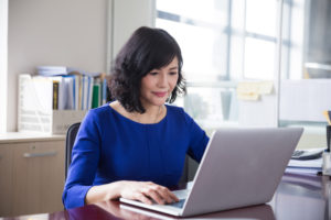 Person using computer at desk to review work