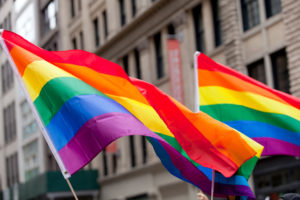 Two Pride flags fly on New York street during a Pride parade