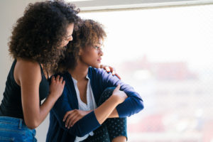 Young woman consoling her friend. 