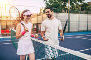A young couple prepares for a tennis match at dawn.