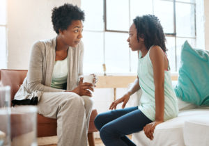 Parent and child sit on chairs having a serious conversation