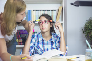 Mother looks over daughter's math homework.