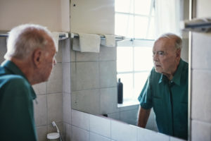 Shot of a senior man looking in his bathroom mirror