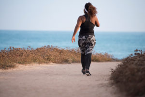 Back view of woman exercising by the sea.