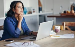 Woman sitting at computer, considering some options