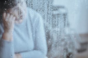 Blurred view of elderly woman with a migraine