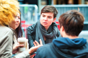 Androgynous college student has coffee with friends