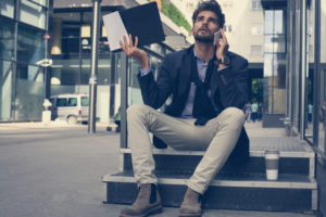 Irritable and stressed businessman takes a call outside the office