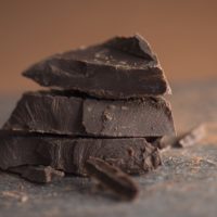 Pieces of dark chocolate with cocoa powder