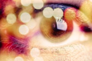 Closeup of a person's eye through colorful lights